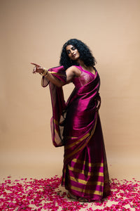 Woman in a vibrant purple saree with gold accents