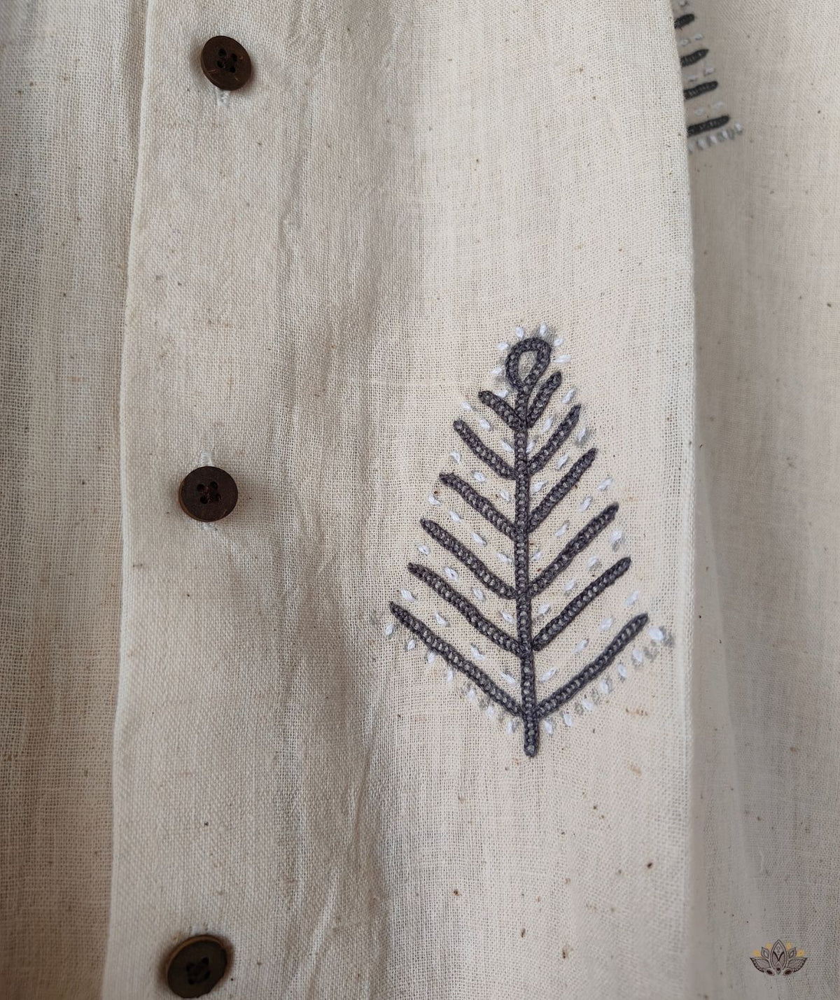 Textile with a leaf pattern and buttons on a beige shirt