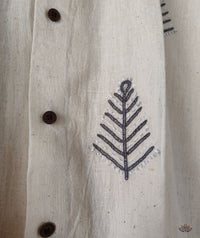 Textile with a leaf pattern and buttons on a beige shirt