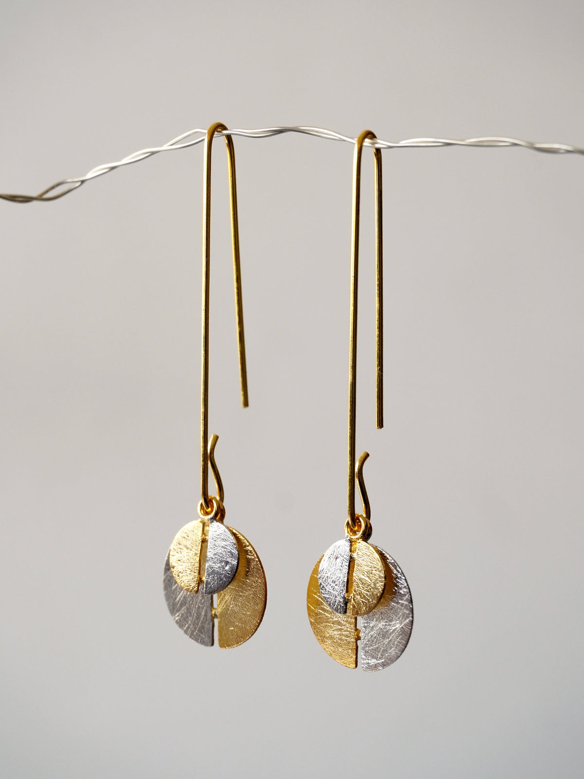Alto Yin Yang De'anma brass symbolic earrings worn model artisan India